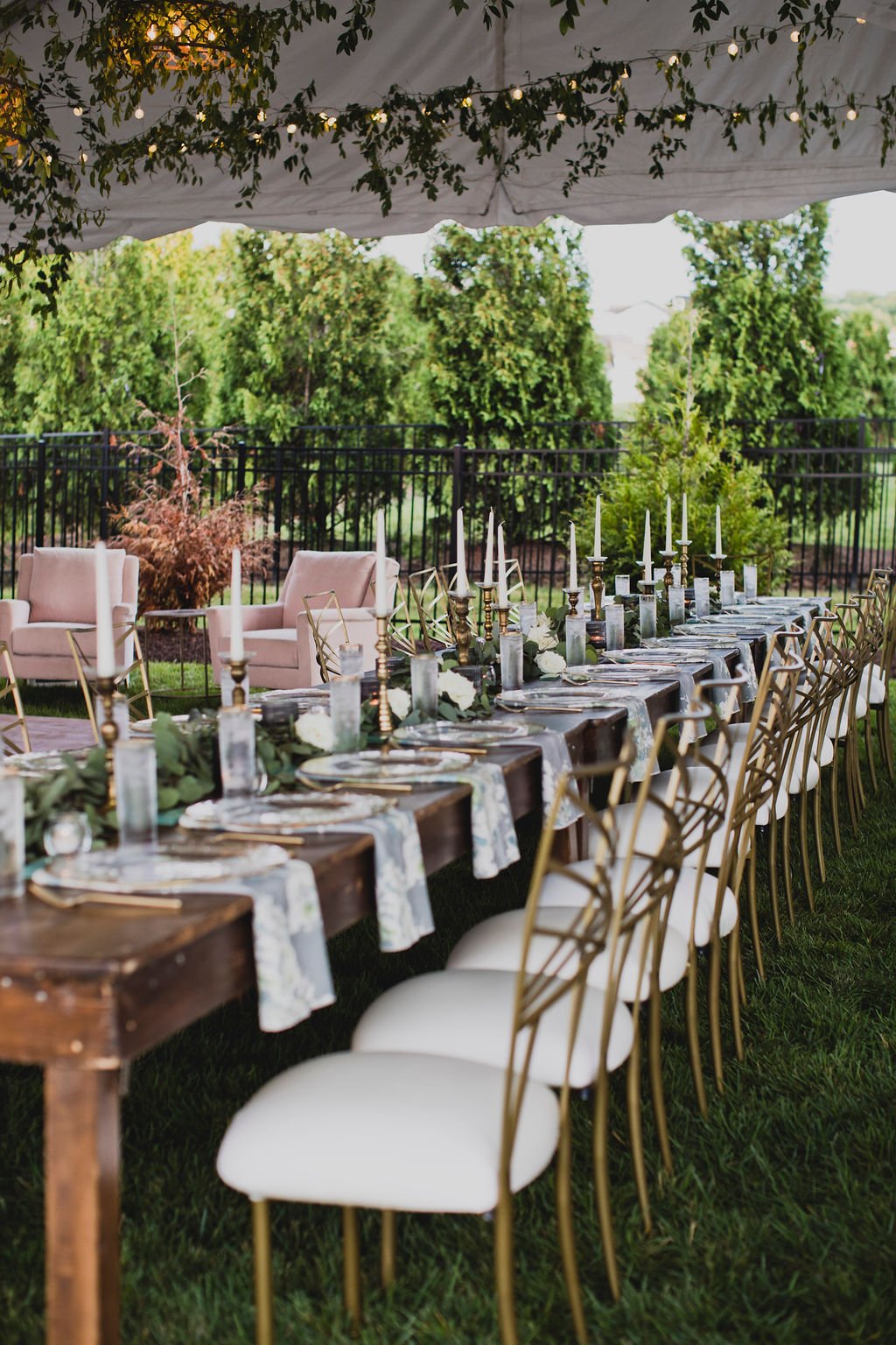This backyard reception had a lush head table filled with garlands of eucalyptus, garden roses, ruscus, and spray roses. Designed by Rosemary and Finch in Nashville, TN