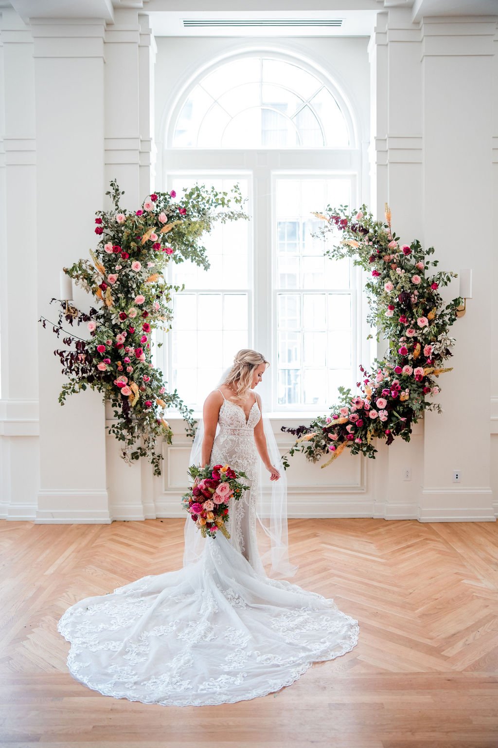 Organic circular floral installation with jewel tone florals featuring garden roses and lush greenery. Nashville wedding floral design at Hotel Noelle.