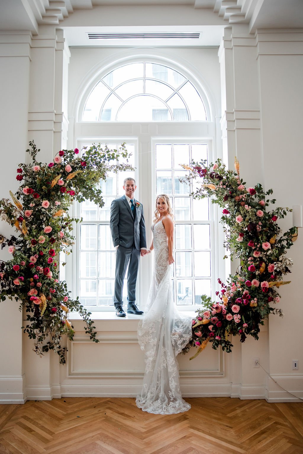 Organic circular floral installation with jewel tone florals featuring garden roses and lush greenery. Nashville wedding floral design at Hotel Noelle.