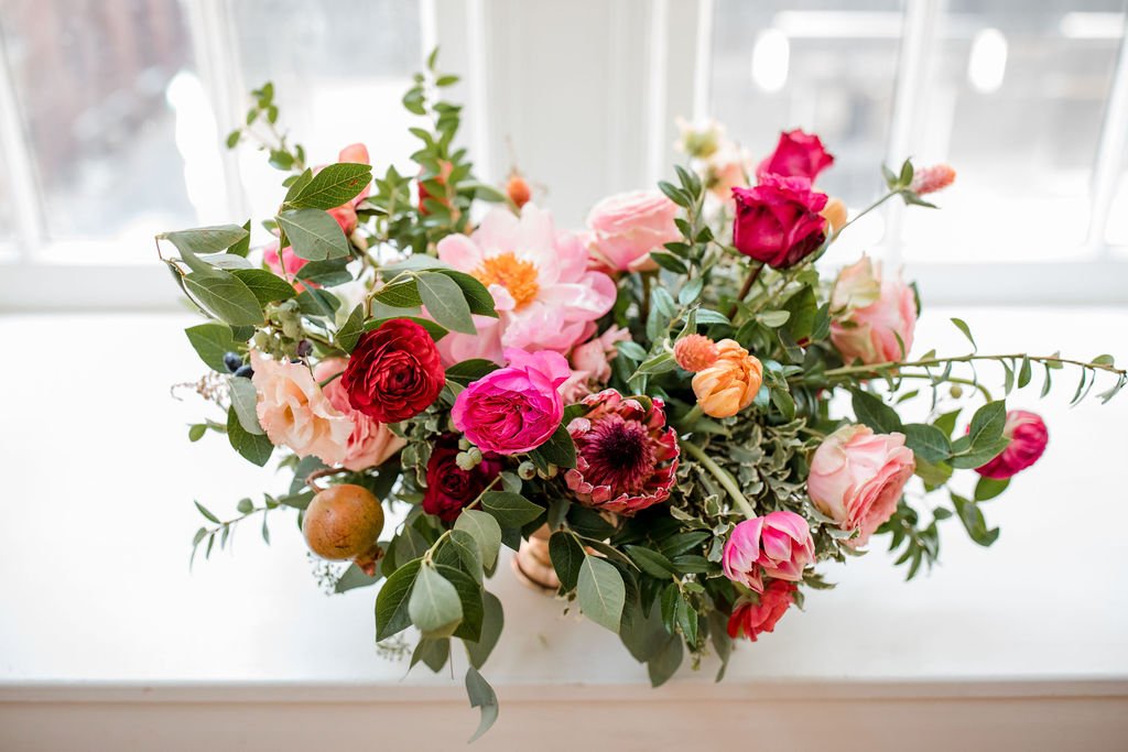 Romantic floral centerpiece with jewel tone flowers and textural elements including garden roses, peonies, ranunculus, tulips and natural greenery. Nashville wedding florist at Hotel Noelle.