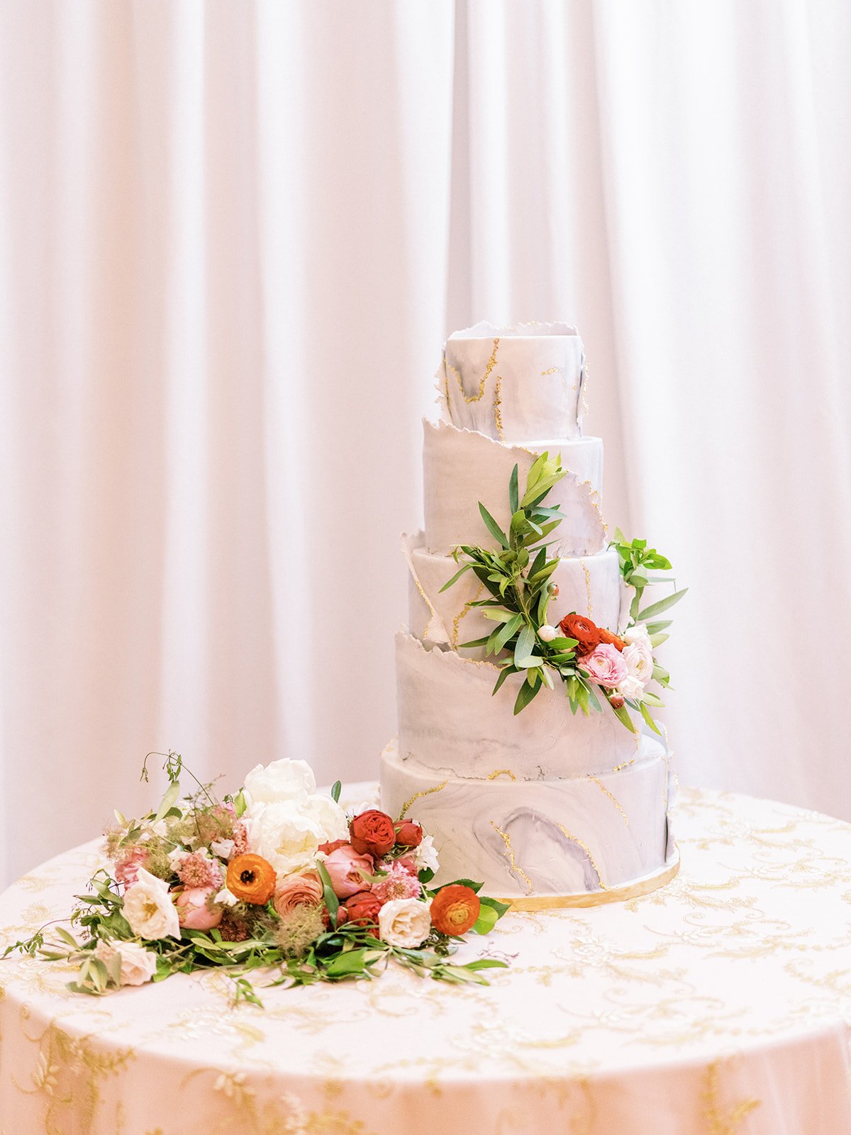 Gorgeous cake florals designed with ranunculus and greenery. Nashville wedding florist at War Memorial.