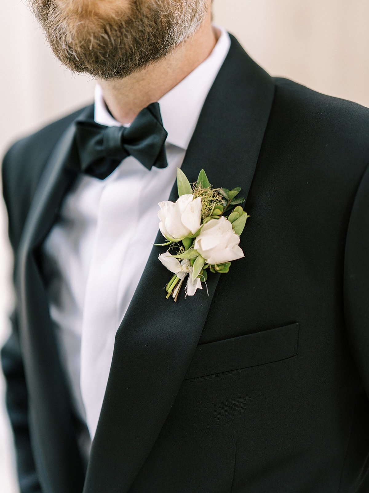 Elegant boutonniere with spray roses, greenery and delicate textures. Designed by Rosemary and Finch in Nashville, TN.