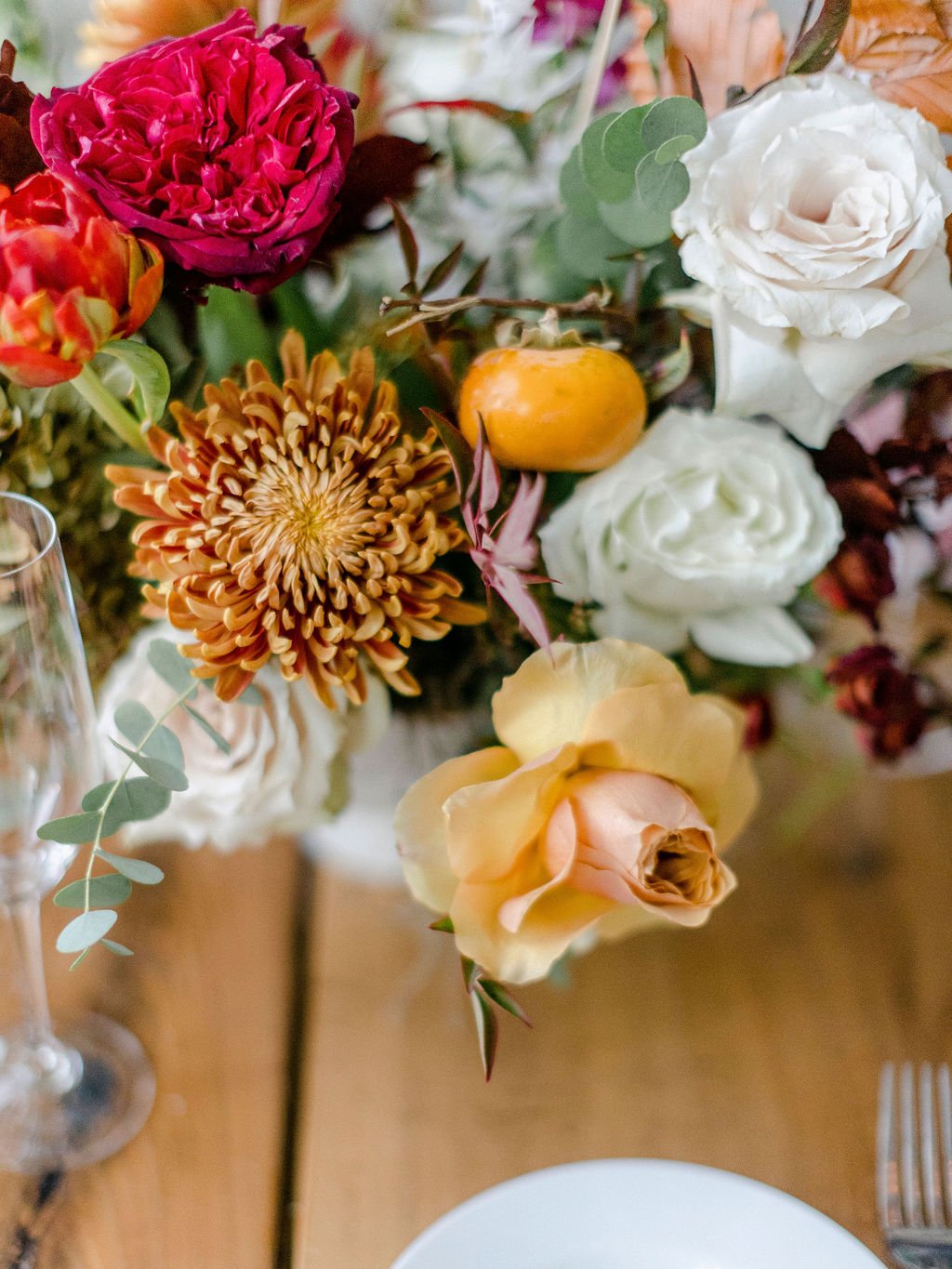 Whimsical bridal party florals featuring vibrant reds, terra cotta, and sage green florals. Fall arrangements with garden roses, tulips, fall branches, dried hydrangea, and eucalyptus.  Floral design by Rosemary and Finch in Nashville, TN.