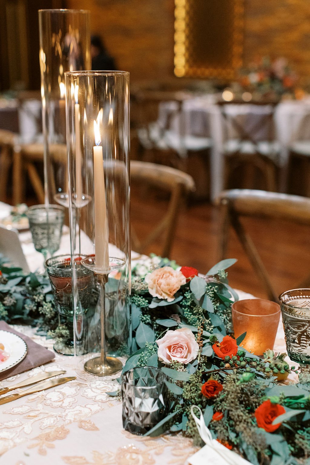 Natural and lush eucalyptus garland centerpiece adorned with burgundy spray roses, garden roses and fruiting branches. Nashville wedding florist at Clementine Hall.