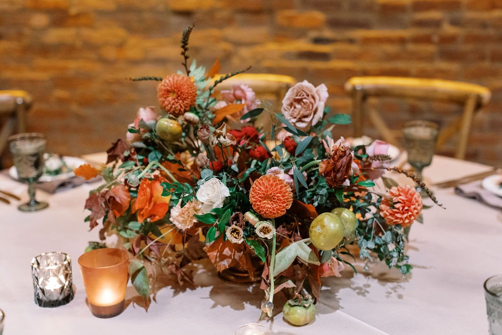 Lush floral centerpiece with autumnal tone flowers and textural elements including garden roses, fruiting branches, ranunculus, dahlias and fall foliage. Nashville wedding florist at Clementine Hall.