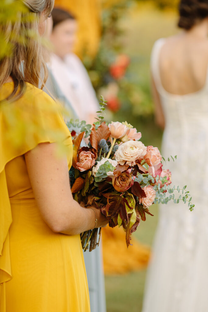 An artful fall bridal bouquet of petal heavy tulips, ranunculus, and garden roses in varying hues of mustard yellow, terra cotta, and dusty rose. Featuring ferns and eucalyptus. Design by Rosemary and Finch in Nashville, TN.