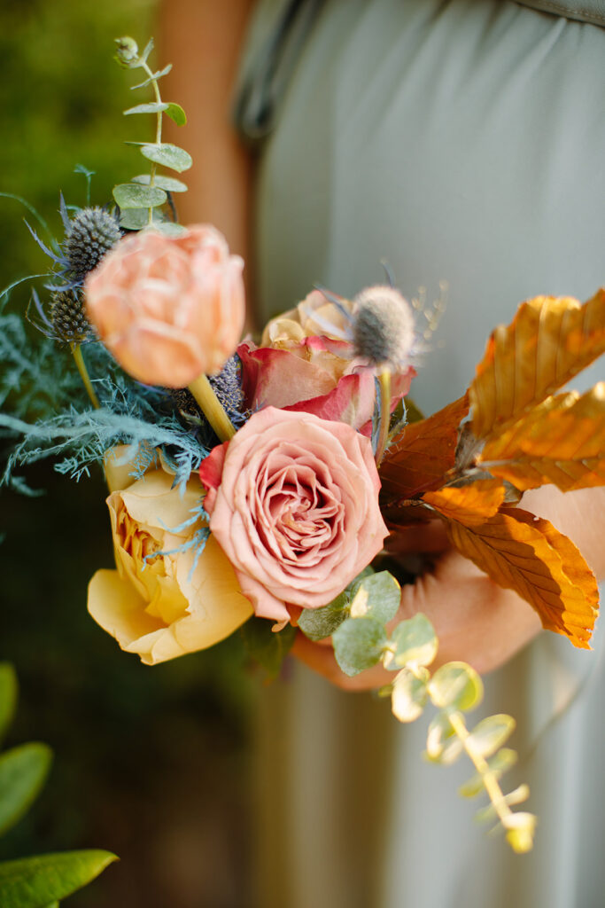 Dainty bridal party florals featuring hues of mustard yellow, dusty rose, sage green, dusty blue, and terra cotta. Fall florals comprised of ranunculus, tulips, garden rose, thistle, ferns, thistle, and eucalyptus. Designed by Rosemary and Finch in Nashville, TN.