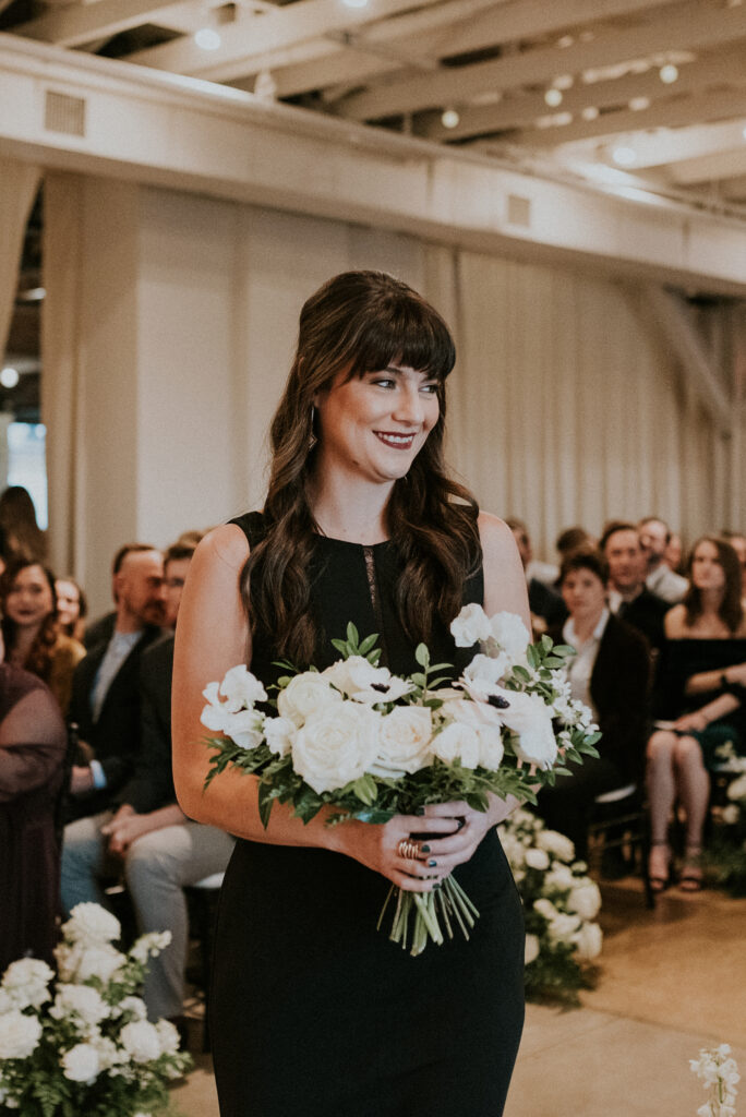 Bridal party florals of white garden roses, panda anemones, ranunculus, sweet peas, delphinium, butterfly ranunculus and dark greenery in floral hues of white, cream, black, and emerald. Designed by Rosemary and Finch in Nashville, TN.