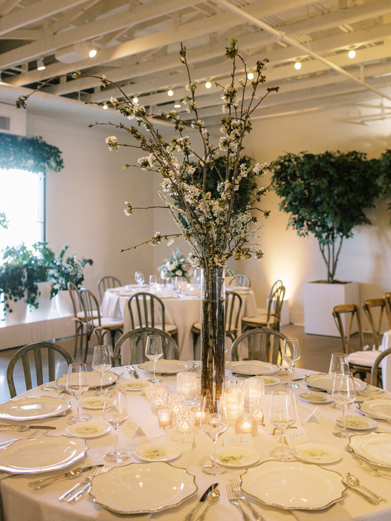Spring fruiting branches table centerpieces add height to this spring garden-inspired wedding reception. Flower colors in pink, white, cream, mauve, lavender, and green. Design by Rosemary and Finch Floral Design in Nashville, TN.
