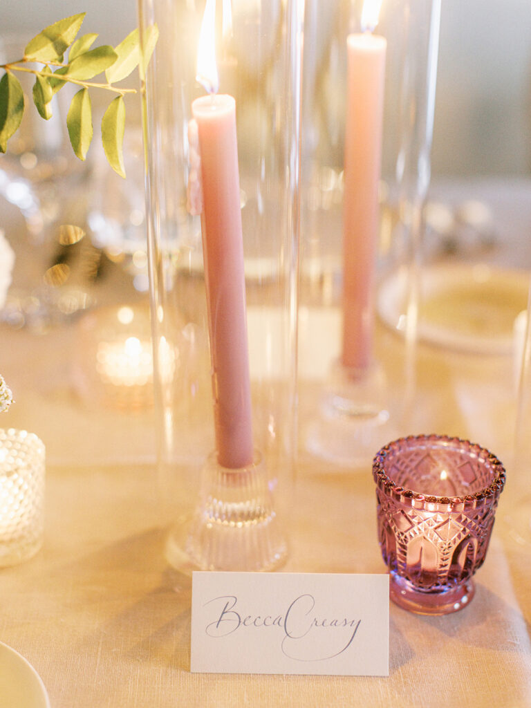 Sparkly wedding reception candles in textured clear glass and shades of pink accenting votives and tapers. Candle heavy tables warming this spring garden-inspired wedding reception in downtown Nashville. Design by Rosemary and Finch Floral Design in Nashville, TN.