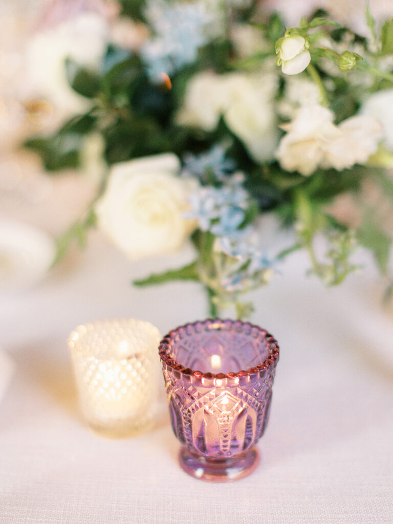 Sparkly wedding reception candles in textured clear glass and shades of pink accenting votives and tapers. Candle heavy tables warming this spring garden-inspired wedding reception in downtown Nashville. Design by Rosemary and Finch Floral Design in Nashville, TN.