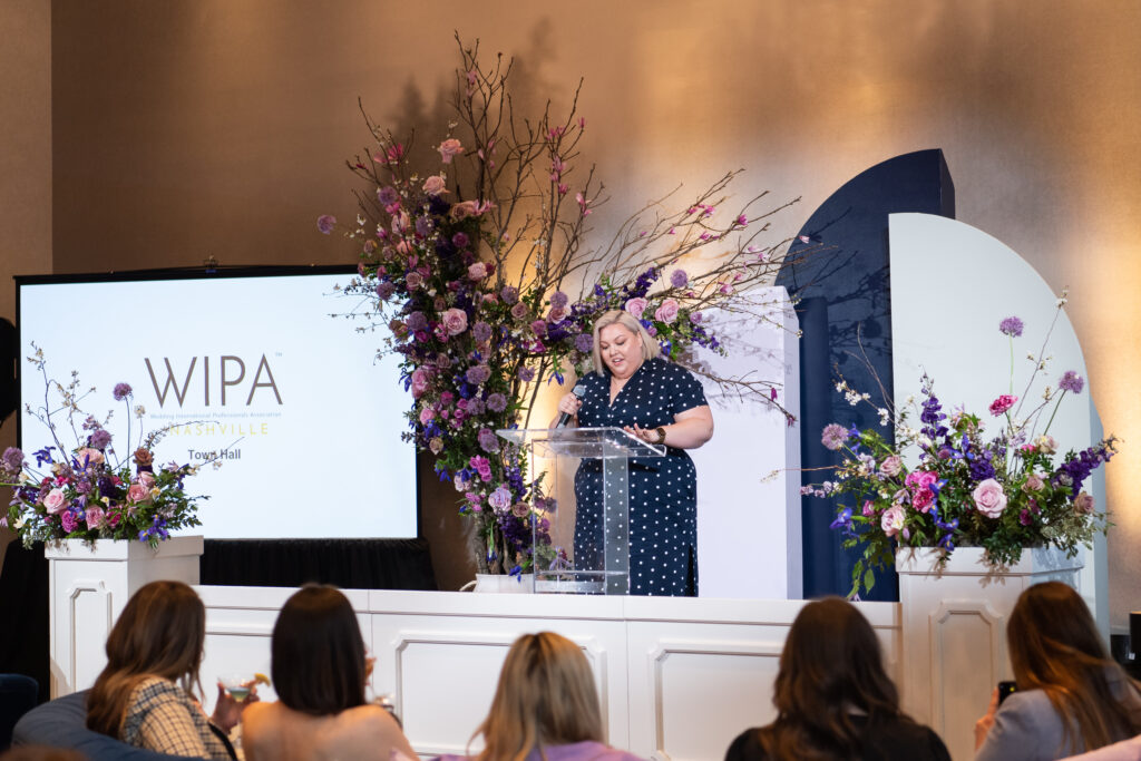 Stunning spring floral tree installation for WIPA Nashville Town Hall highlighted by purple TN Irises, dusty pink roses, purple allium, and blooming spring branches. Corporate industry event florals in Downtown Nashville. Design by Rosemary and Finch Floral Design in Nashville, TN.