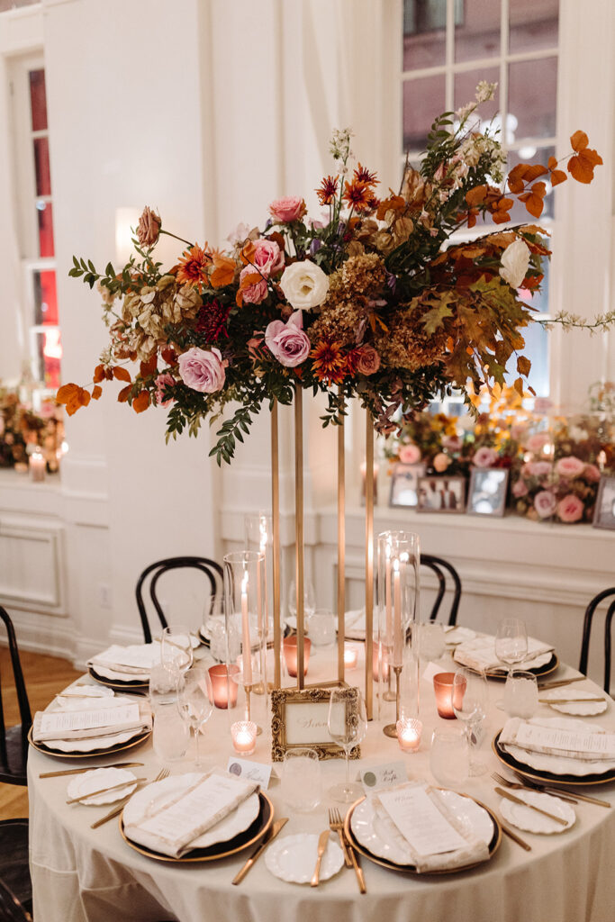 Eye-catching elevated centerpieces complete this Parisian inspired fall wedding with colors of dusty rose, terra cotta, burgundy, mauve, lavender, and copper composed of roses, mums, lisianthus, clematis, delphinium, copper beech, dried hydrangea, and fall foliage. Fall wedding in Downtown Nashville. Design by Rosemary & Finch Floral Design in Nashville, TN.