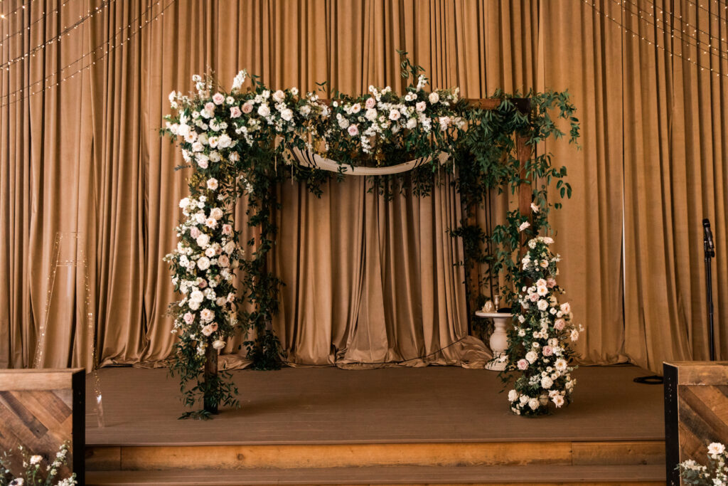 Timeless chuppah floral design for fall wedding ceremony and reception in Nashville, TN. Timeless floral colors in white, cream, and blush. Growing organic floral design for chuppah with roses and natural greenery. Destination wedding floral design. Design by Rosemary & Finch Floral Design in Nashville, TN. 