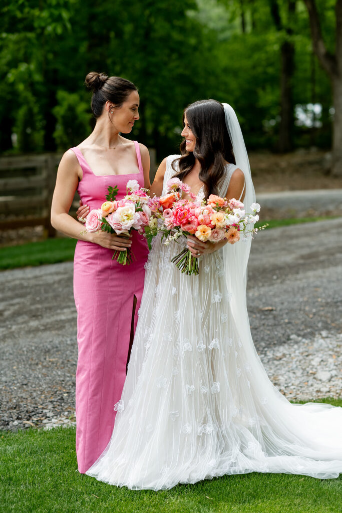 Floral heavy pink bridesmaids’ bouquets featuring peak spring blooms. Bouquet featuring peonies, tulips, ranunculus, butterfly ranunculus, and rose flowers in pink, blush, white, and peach colors. Pink spring wedding outside Nashville, TN. Design by Rosemary & Finch Floral Design in Nashville, TN. 
