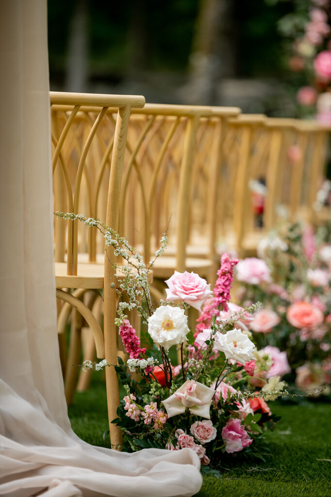 Lush ceremony aisle florals for spring wedding in countryside. Vibrant pink florals in these aisle markers bring pops of color to this destination wedding outside Nashville, TN. Pink roses and peak spring flowers bring fun colors for this spring wedding ceremony. Design by Rosemary & Finch Floral Design in Nashville, TN.