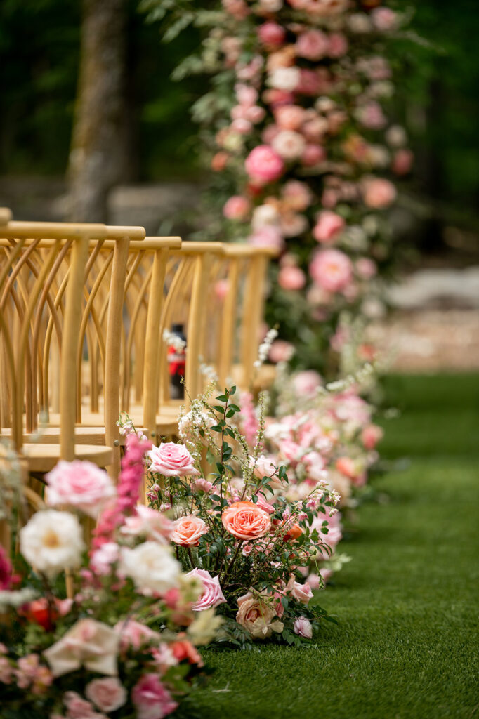Lush ceremony aisle florals for spring wedding in countryside. Vibrant pink florals in these aisle markers bring pops of color to this destination wedding outside Nashville, TN. Pink roses and peak spring flowers bring fun colors for this spring wedding ceremony. Design by Rosemary & Finch Floral Design in Nashville, TN.