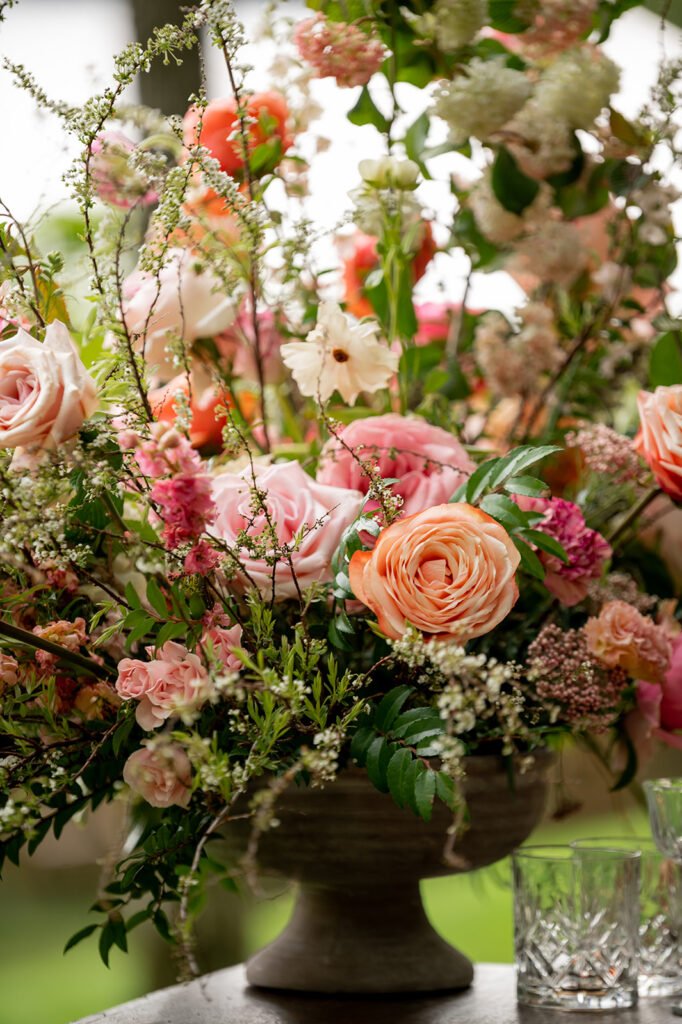 Whimsical cocktail bar statement floral arrangement brings a pop of color to this spring outdoor wedding. Vibrant color palettes of pink, peach, blush, and cream flowers bring this wedding reception fun florals. Destination countryside wedding outside Nashville, TN. Design by Rosemary & Finch Floral Design in Nashville, TN. 