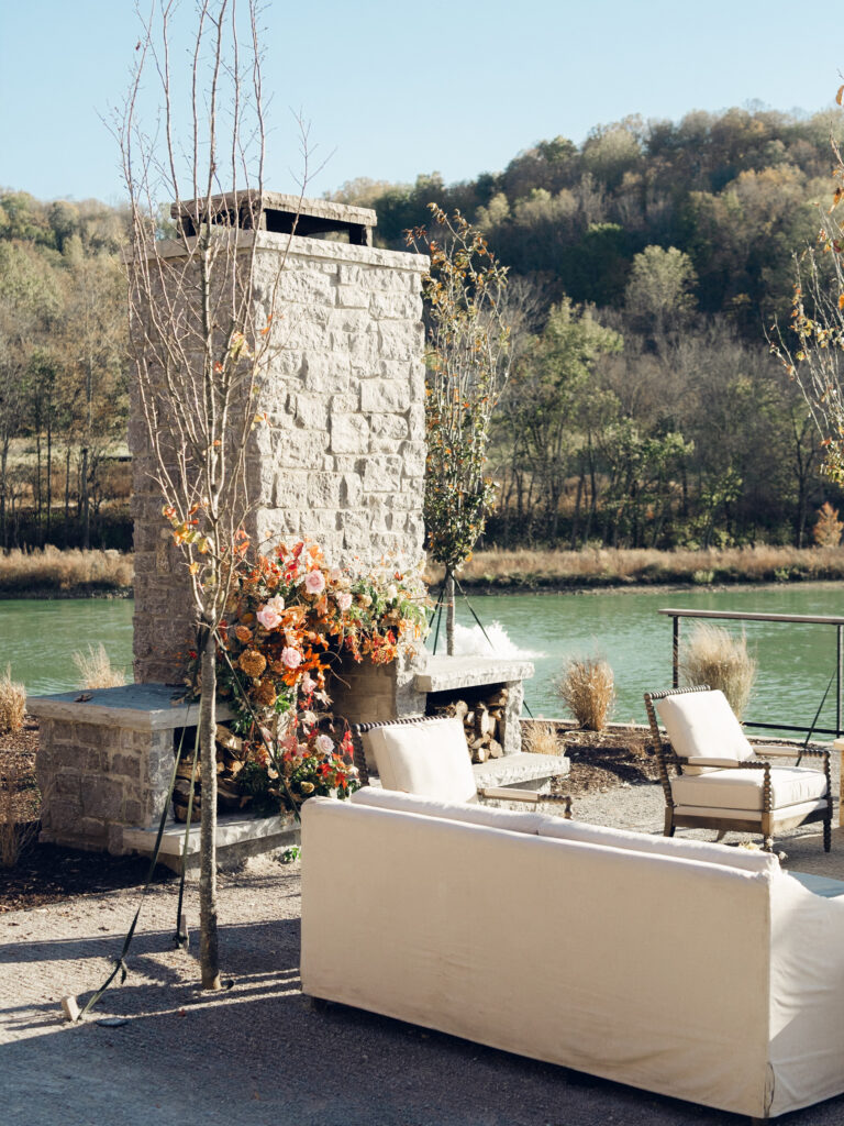 Fireplace floral moment for fall wedding reception at Southall Farm & Inn. Lush floral moment on fireplace in unique floral palette caramel, honey, dusty rose, peach, copper, and burgundy. Fall foliage and roses decorate this cocktail hour lounge area. Destination wedding outside Nashville, TN. Design by Rosemary & Finch Floral Design in Nashville, TN. 