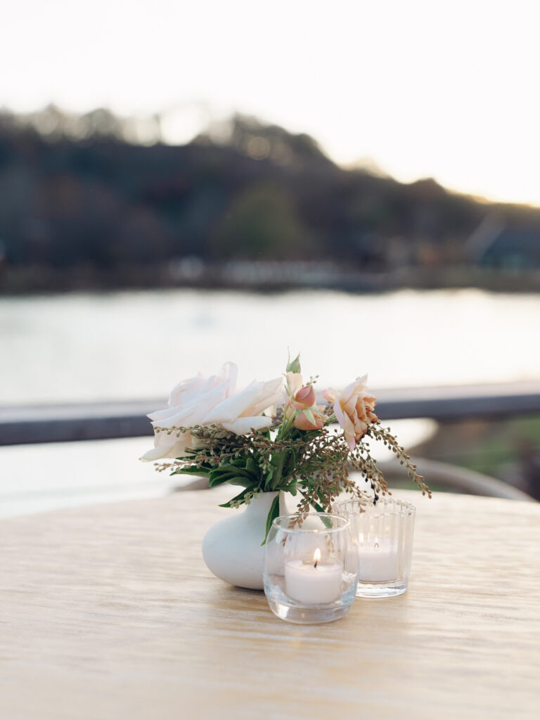 Whimsical bud vases decorate the cocktail hour of this fall wedding reception outside Nashville, TN. Unique floral textures and colors with roses and fall foliage. Fall wedding colors in dusty rose, peach, copper, caramel, and honey. Ceramic bud vases with small votives candles. Destination weddings floral design in Tennessee countryside. Design by Rosemary & Finch Floral Design in Nashville, TN.