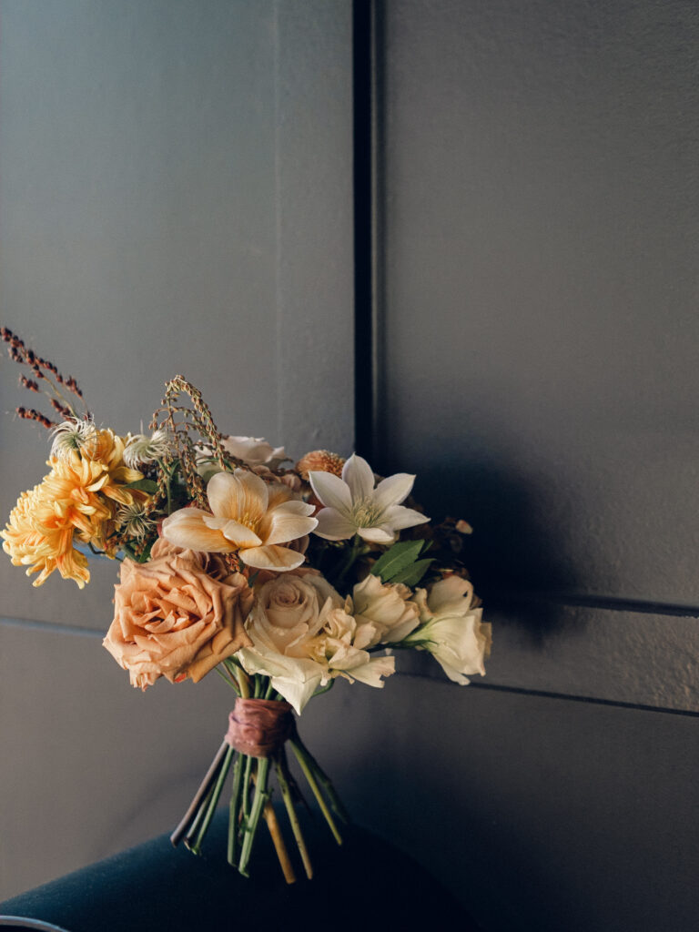 Whimsical bridesmaids’ bouquets in unique fall tones caramel, dusty rose, peach, tangerine, and copper. Fall floral bouquet with roses, ranunculus, mums, fruiting branches, and clematis. Medium sized bridal bouquet with fall colors. Destination wedding outside Nashville, TN. Design by Rosemary & Finch Floral Design in Nashville, TN. 