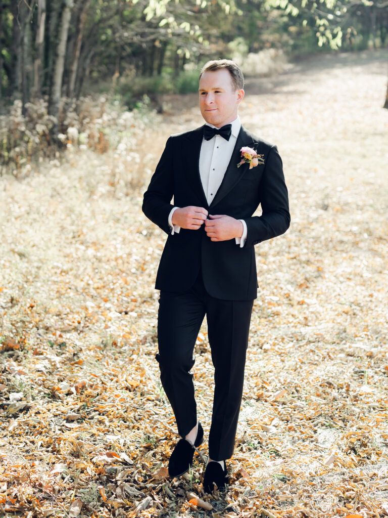 Unique fall floral boutonniere for groom and groomsmen in dusty rose, copper, tangerine, honey, and caramel flower colors. Ranunculus and wildflower fall boutonniere. Destination wedding in Tennessee countryside. Floral design by Rosemary & Finch Floral Design in Nashville, TN.