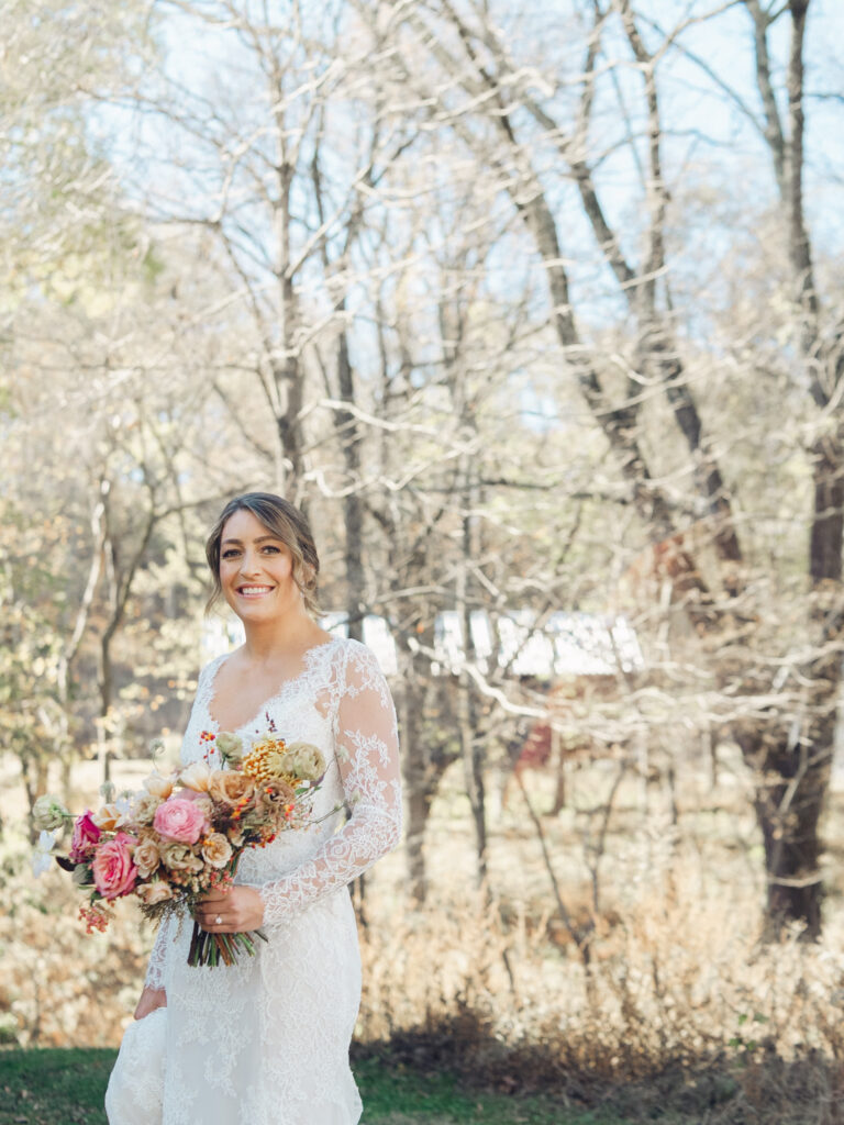 Whimsical bridal bouquet in unique fall tones caramel, dusty rose, peach, tangerine, and copper. Fall floral bouquet with roses, ranunculus, mums, fruiting branches, and clematis. Medium sized bridal bouquet with fall colors. Destination wedding outside Nashville, TN. Design by Rosemary & Finch Floral Design in Nashville, TN. 