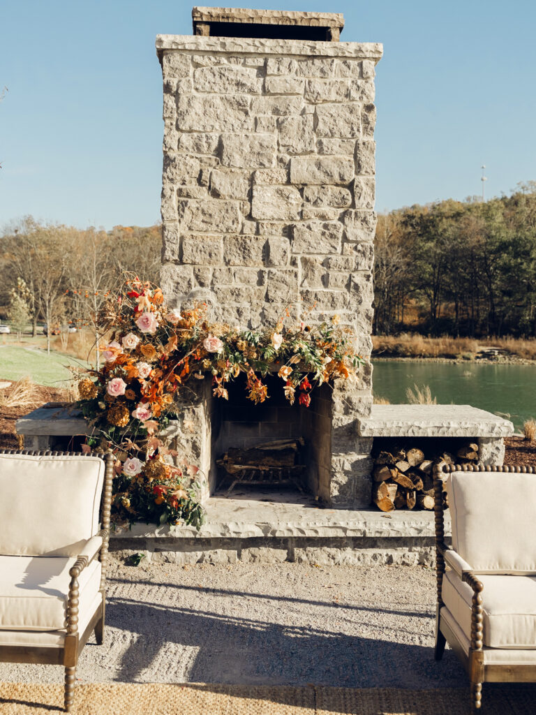 Fireplace floral moment for fall wedding reception at Southall Farm & Inn. Lush floral moment on fireplace in unique floral palette caramel, honey, dusty rose, peach, copper, and burgundy. Fall foliage and roses decorate this cocktail hour lounge area. Destination wedding outside Nashville, TN. Design by Rosemary & Finch Floral Design in Nashville, TN. 