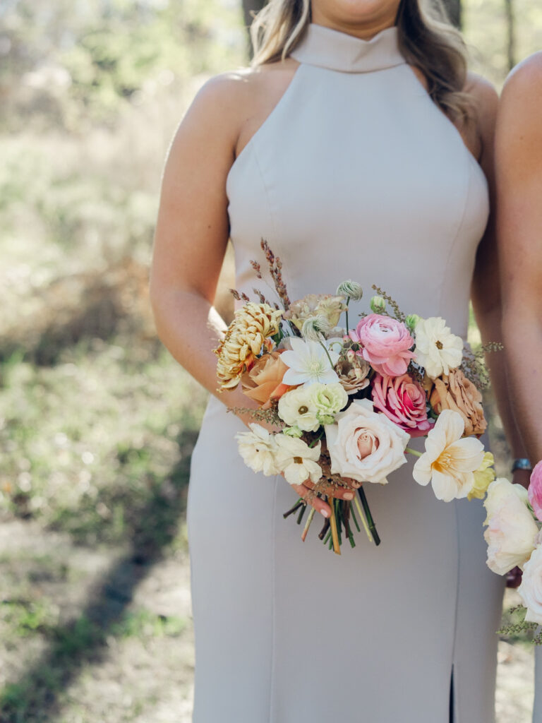 Whimsical bridesmaids’ bouquets in unique fall tones caramel, dusty rose, peach, tangerine, and copper. Fall floral bouquet with roses, ranunculus, mums, fruiting branches, and clematis. Medium sized bridal bouquet with fall colors. Destination wedding outside Nashville, TN. Design by Rosemary & Finch Floral Design in Nashville, TN. 