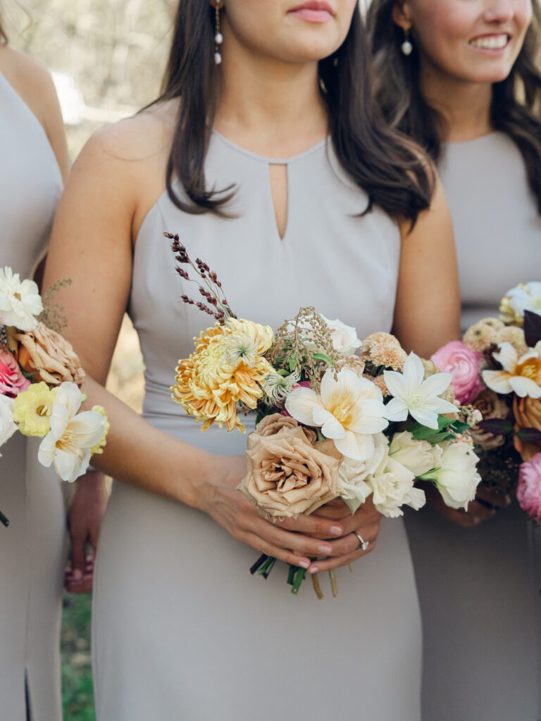 Whimsical bridesmaids’ bouquets in unique fall tones caramel, dusty rose, peach, tangerine, and copper. Fall floral bouquet with roses, ranunculus, mums, fruiting branches, and clematis. Medium sized bridal bouquet with fall colors. Destination wedding outside Nashville, TN. Design by Rosemary & Finch Floral Design in Nashville, TN. 