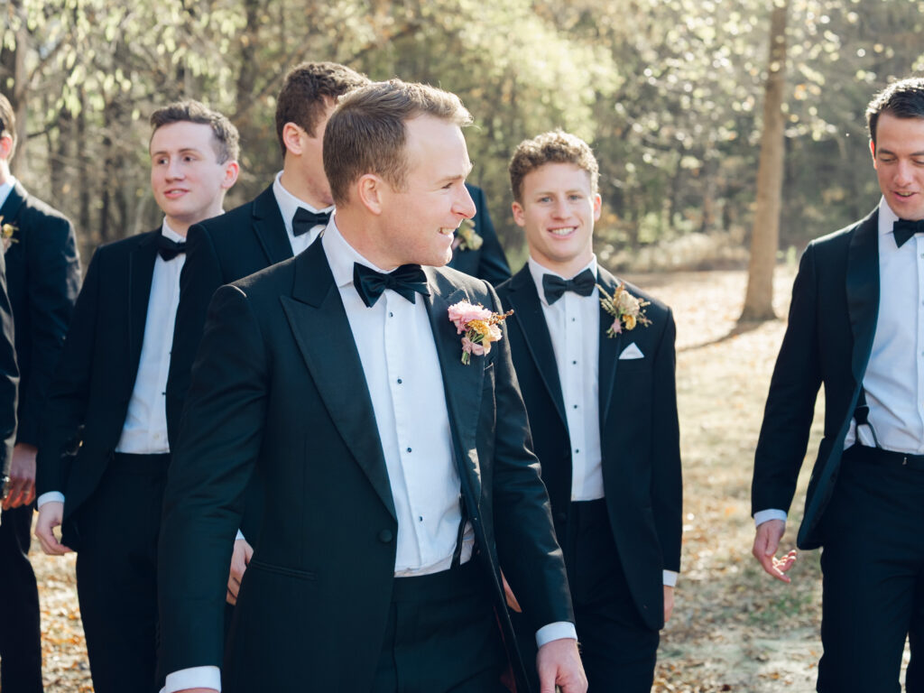 Unique fall floral boutonniere for groom and groomsmen in dusty rose, copper, tangerine, honey, and caramel flower colors. Ranunculus and wildflower fall boutonniere. Destination wedding in Tennessee countryside. Floral design by Rosemary & Finch Floral Design in Nashville, TN.