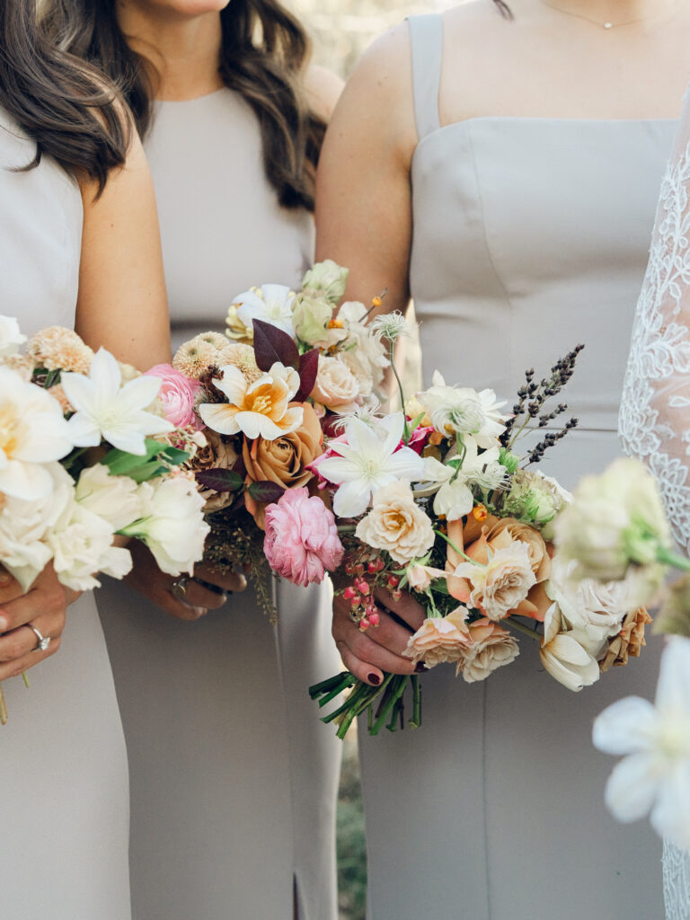 Whimsical bridesmaids’ bouquets in unique fall tones caramel, dusty rose, peach, tangerine, and copper. Fall floral bouquet with roses, ranunculus, mums, fruiting branches, and clematis. Medium sized bridal bouquet with fall colors. Destination wedding outside Nashville, TN. Design by Rosemary & Finch Floral Design in Nashville, TN. 