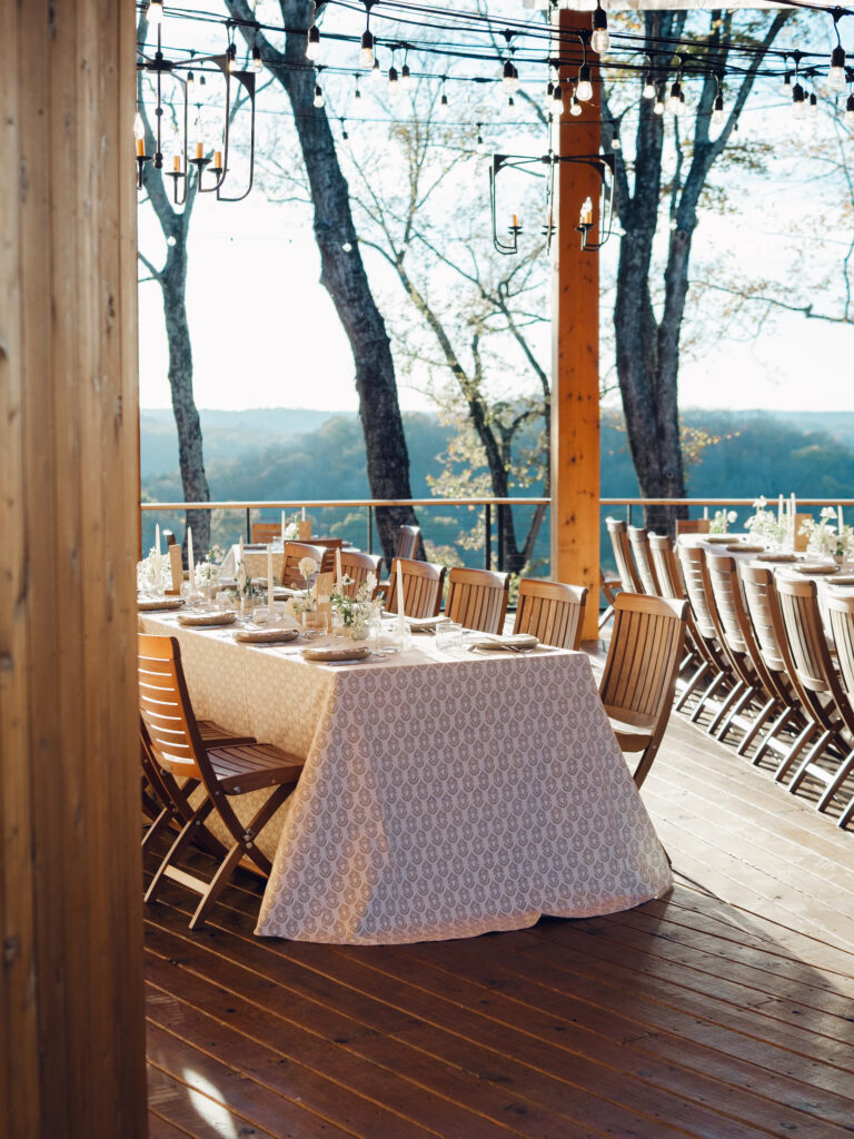 Rehearsal dinner on hilltop of Tennessee countryside resort Southall Farm & Inn. Ikebana style floral arrangements for rehearsal dinner of fall wedding. Classic whimsical white florals decorate this dinner reception with timeless garden-inspired floral design. Destination wedding outside Nashville, TN. Design by Rosemary & Finch Floral Design in Nashville, TN. 