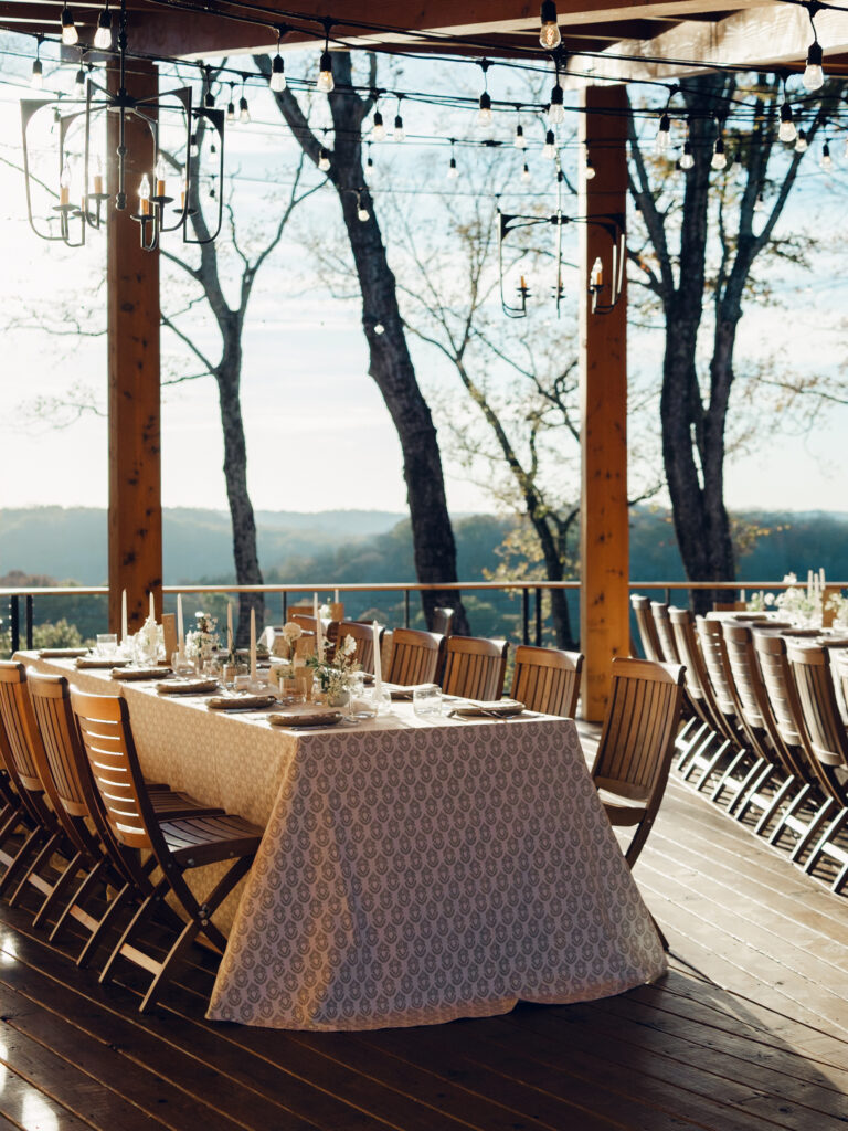 Rehearsal dinner on hilltop of Tennessee countryside resort Southall Farm & Inn. Ikebana style floral arrangements for rehearsal dinner of fall wedding. Classic whimsical white florals decorate this dinner reception with timeless garden-inspired floral design. Destination wedding outside Nashville, TN. Design by Rosemary & Finch Floral Design in Nashville, TN. 