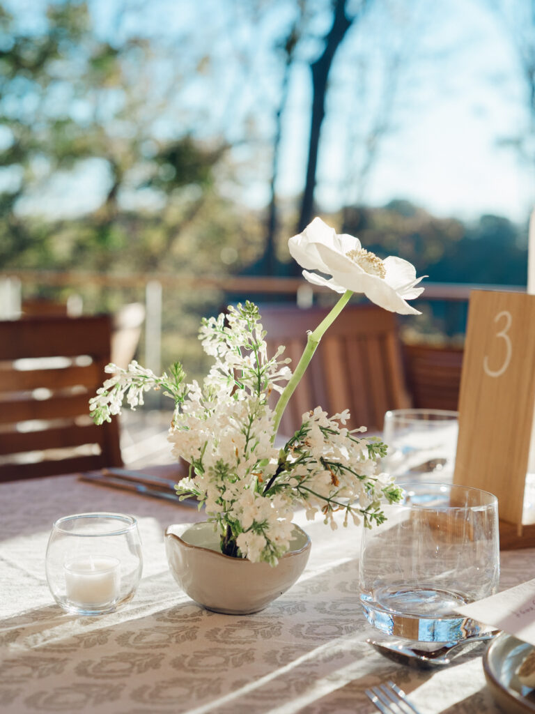 Rehearsal dinner on hilltop of Tennessee countryside resort Southall Farm & Inn. Ikebana style floral arrangements for rehearsal dinner of fall wedding. Classic whimsical white florals decorate this dinner reception with timeless garden-inspired floral design. Destination wedding outside Nashville, TN. Design by Rosemary & Finch Floral Design in Nashville, TN. 