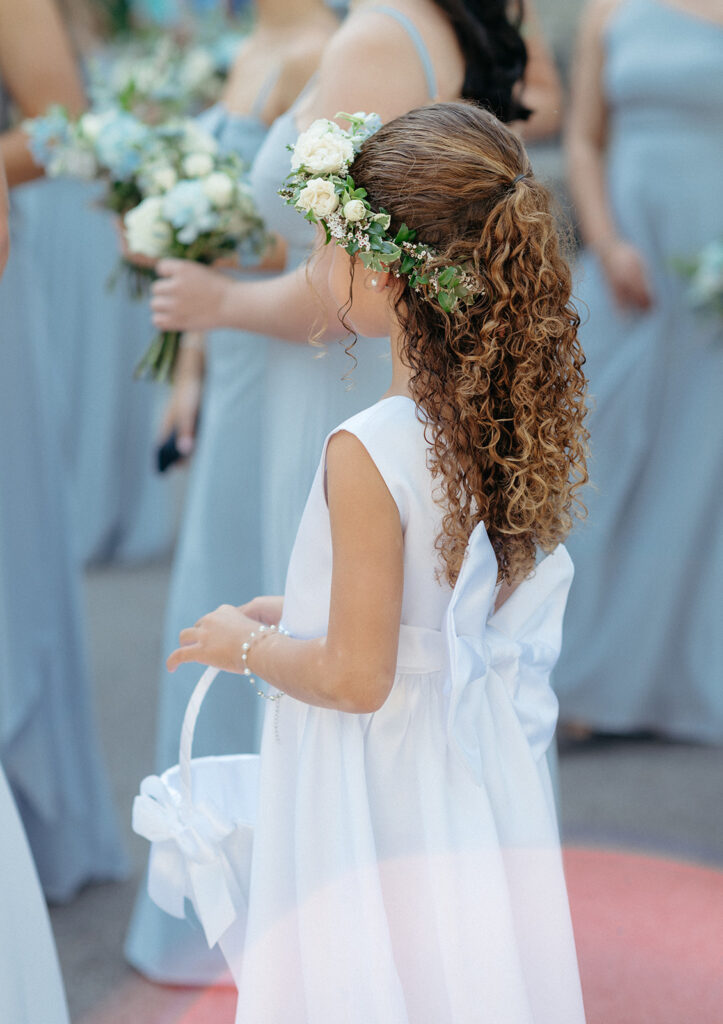 White floral crown for flower girl in wedding ceremony. Dainty florals create a headpiece for the flower girls. Floral crown with white roses and natural greenery. Design by Rosemary & Finch in Nashville, TN.