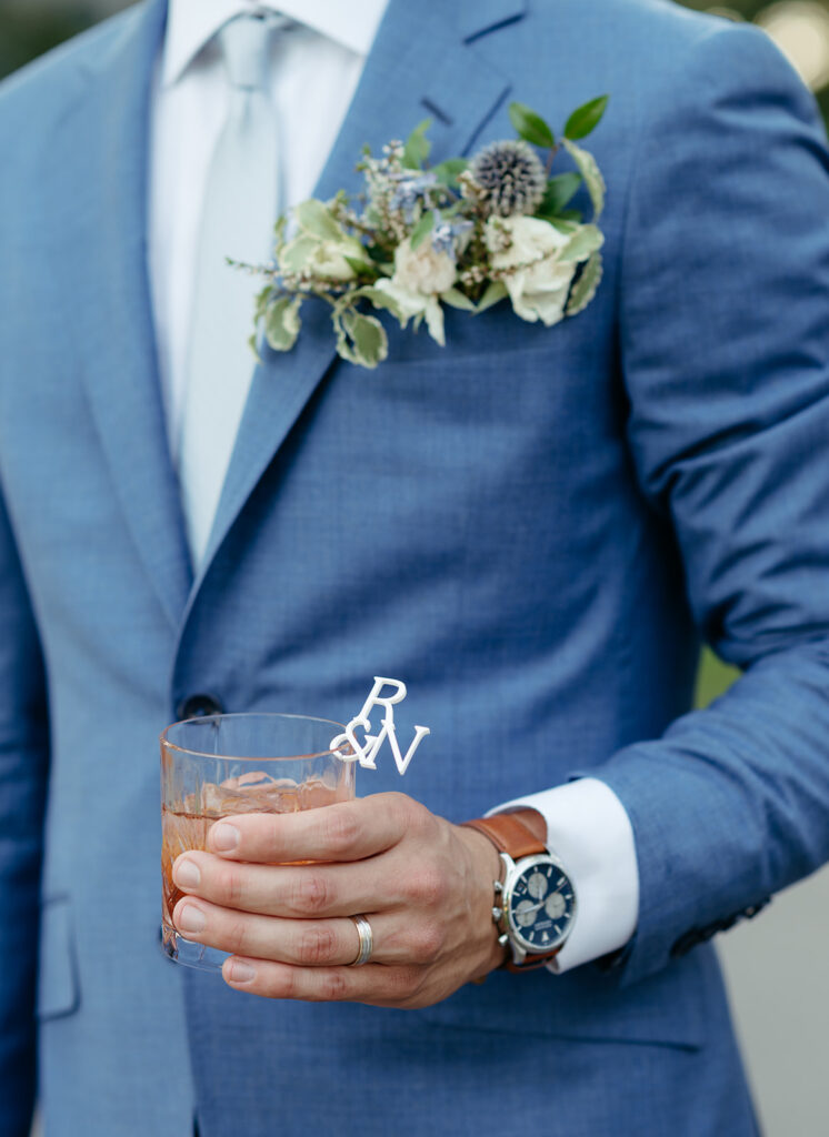 Pocket square boutonniere with white roses and natural greenery. Boutonniere for blue and white summer wedding. Summer floral design for outdoor wedding. Design by Rosemary & Finch in Nashville, TN.