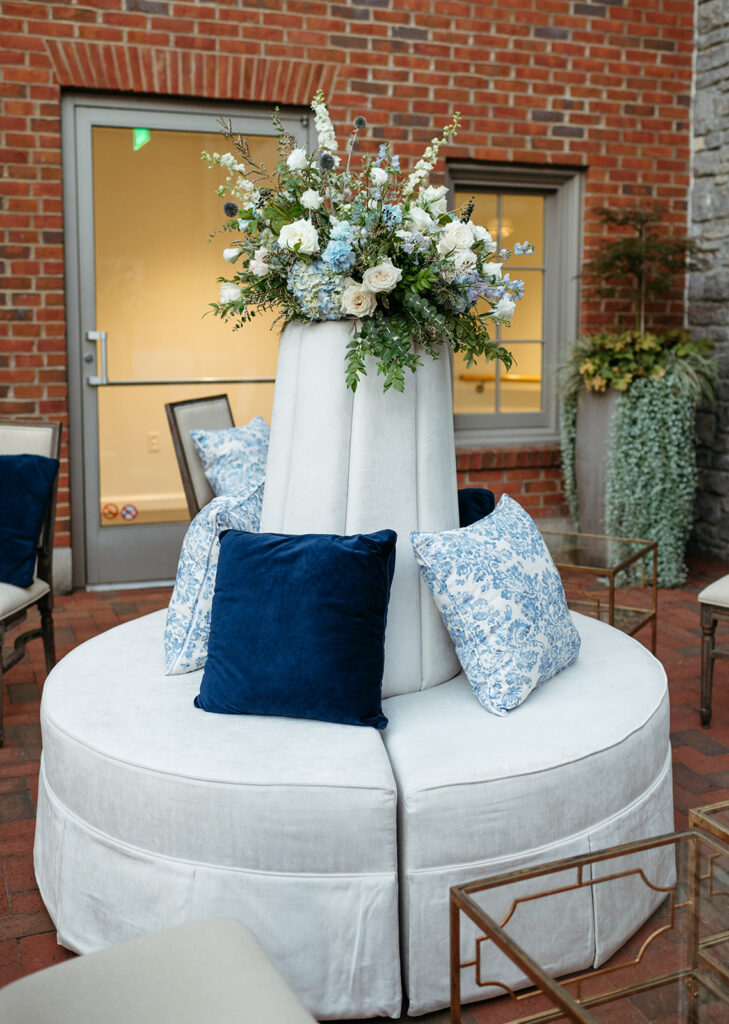 Outdoor wedding reception florals for cocktail hour. Bud vases for cocktail hour with summer wildflowers. Blue and white wedding florals for summer wedding decorate the cocktail hour bar for outdoor wedding reception. Elevated floral arrangements for outdoor lounge area. Design by Rosemary & Finch in Nashville, TN.