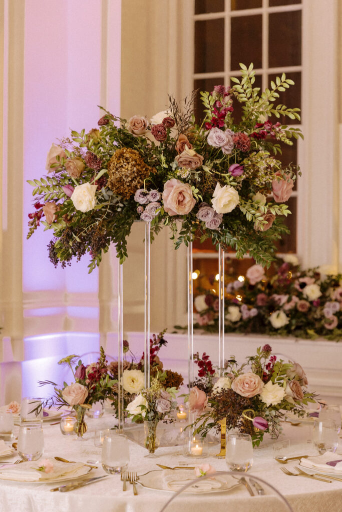 Elevated statement wedding table floral arrangements. Flowers in mauve, eggplant, plum, and cream. Roses, scabiosa, berries, and branches. Floral textures for fall wedding. Fall wedding in downtown Nashville with purple wedding colors. Design by Rosemary & Finch Floral Design in Nashville, TN. 