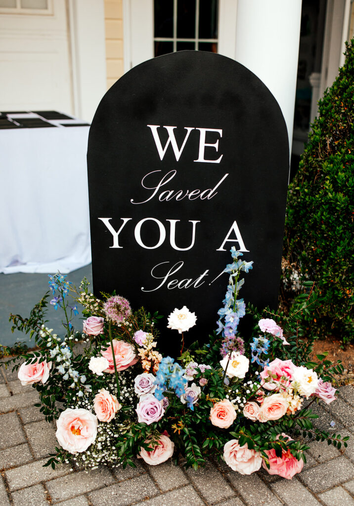 Wedding welcome sign with ground florals. Colorful and fun wedding flowers for summer wedding. Pastel color scheme in purple, pink, blue, and peach for summer wedding in Nashville, TN. Design by Rosemary & Finch Floral Design in Nashville, TN.