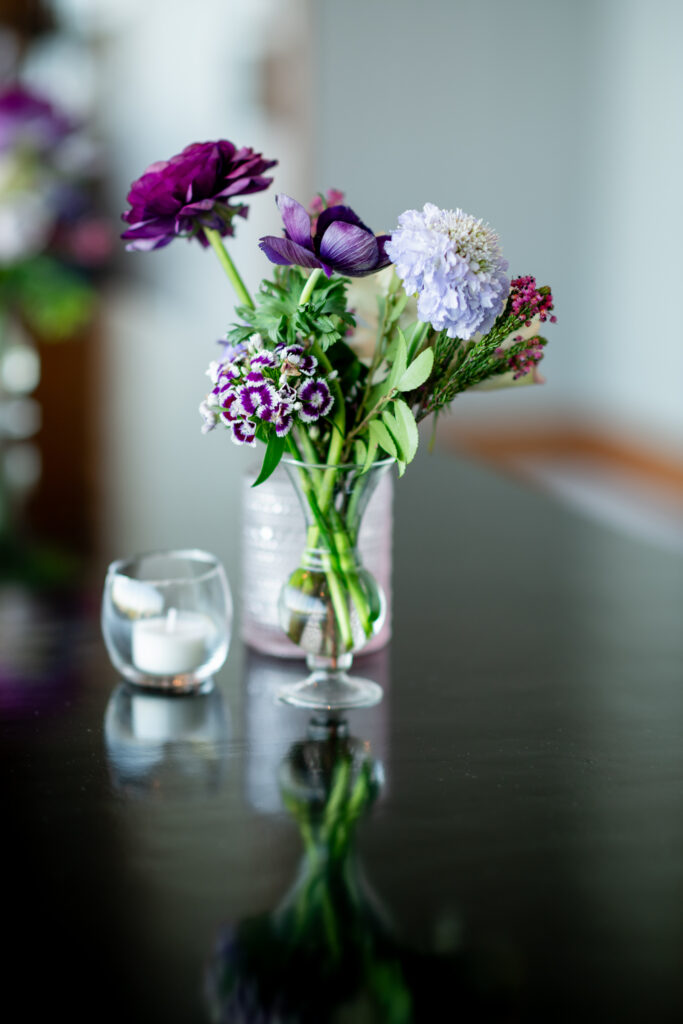 Elegant cocktail hour florals decorate the bar and cocktail tables of this fall wedding reception. Purple wedding flowers in hues of lavender, mauve, blush, and plum. Fall wildflowers for fall wedding reception. Design by Rosemary & Finch Floral Design in Nashville, TN. 