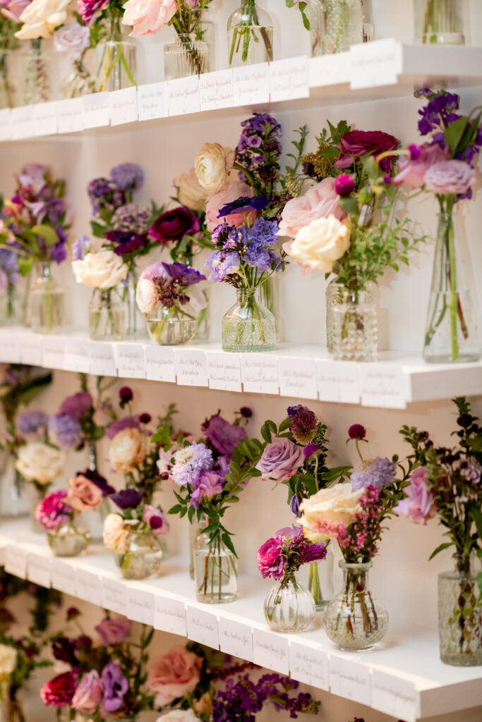 Elegant bud vases decorate the escort display of this fall wedding reception. Purple wedding flowers in hues of lavender, mauve, blush, and plum. Fall wildflowers for fall wedding reception. Design by Rosemary & Finch Floral Design in Nashville, TN. 