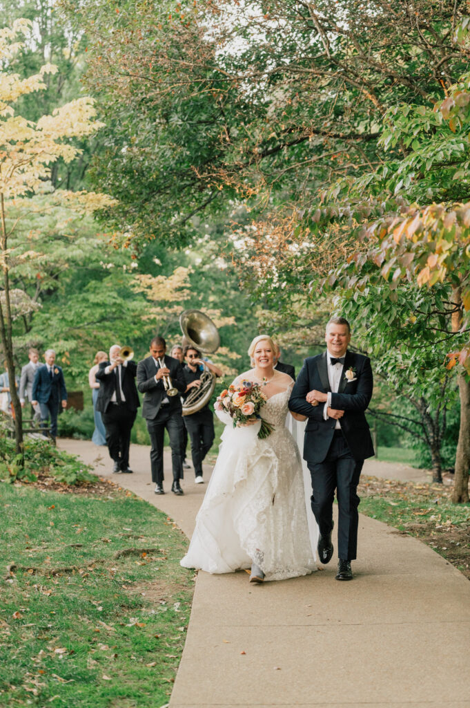 Second line wedding ceremony exit. Unique wedding exits with band for fall wedding ceremony in Nashville, TN. Fall bridal bouquet with local wildflowers. Timeless fall wedding colors for outdoor wedding with touches of gold. Fall floral colors with touches of pink, golden yellow, blue, and burgundy. Fall wildflowers for outdoor wedding in Tennessee. Local fall flowers of zinnias, dahlias, and roses for fall wedding. Design by Rosemary & Finch Floral Design in Nashville, TN.