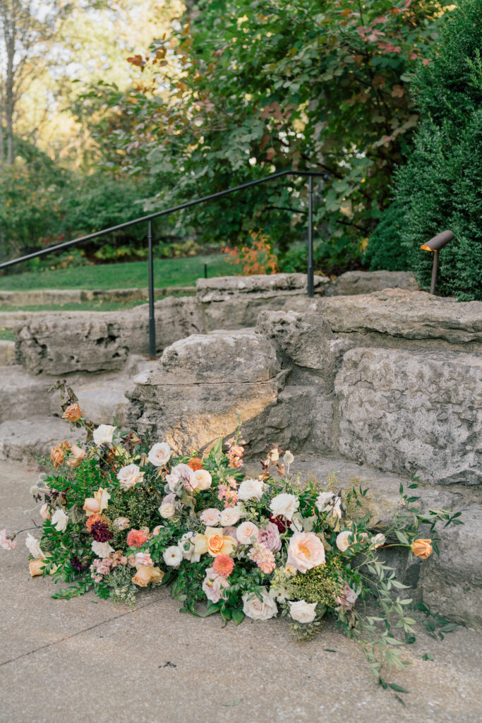 Fall wedding outdoor ceremony florals for intimate wedding in Nashville, TN. Floral ground meadows for fall wedding ceremony. Natural growing florals accents fall wedding ceremony with. Fall floral colors with touches of pink, golden yellow, blue, and burgundy. Fall wildflowers for outdoor wedding in Tennessee. Local fall flowers of zinnias, dahlias, and roses for fall wedding. Design by Rosemary & Finch Floral Design in Nashville, TN.
