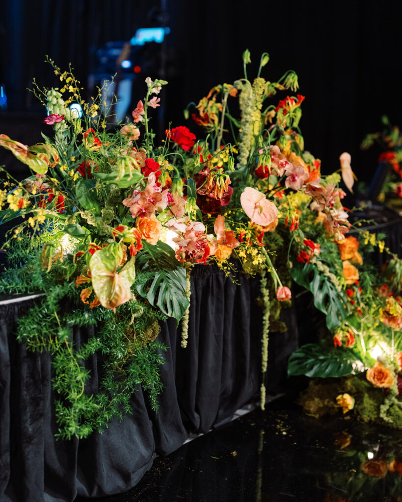 Unique growing stage florals for planner event at the Four Seasons Nashville. Unique and fun florals in bright colors. Floral colors in chartreuse, red, magenta, yellow, blush, and peach. Colorful floral design with orchids, poppies, tropical flowers, and amaranthus. Funky event design with tropical florals and leopard print accents. Design by Rosemary & Finch Floral Design in Nashville, TN.