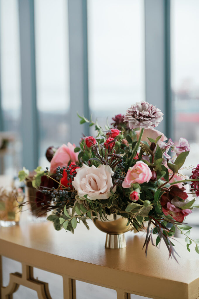 Cocktail hour florals for winter wedding. Moody jewel tone wedding reception florals in ruby, blush, plum, and magenta. Bar menu floral meadows for wedding reception bar. Escort Display mirrors with floral meadows. Unique floral touches in cocktail reception of winter wedding in downtown Nashville. Design by Rosemary & Finch Floral Design.