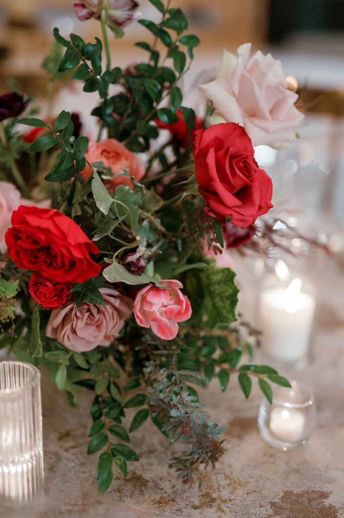 Floral forward low centerpieces for winter wedding. Jewel tone winter wedding color palette. Destination floral design in Nashville, TN. Winter floral colors in ruby, blush, plum, and magenta. Design by Rosemary & Finch Floral Design.