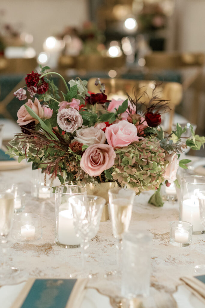 Floral forward low centerpieces for winter wedding. Jewel tone winter wedding color palette. Destination floral design in Nashville, TN. Winter floral colors in ruby, blush, plum, and magenta. Design by Rosemary & Finch Floral Design.