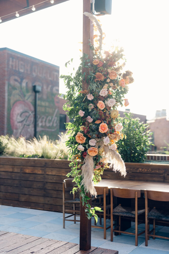 Oyster bar with floral accent installations for wedding party. Boho themed wedding welcome party with fall florals, pampas grass, and fall foliage. Fall event décor with fall foliage and florals in cream, copper, rust, and natural greens. Design by Rosemary & Finch Floral & Finch. 