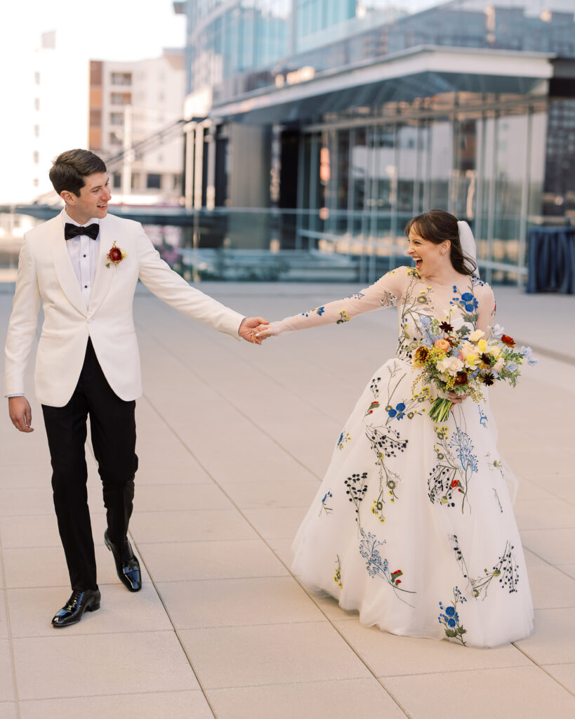 This bridal bouquet features a stunning mix of flowers in a pastel color palette, creating an elegant and romantic look. The combination of soft pastels with darker accents provides a beautiful contrast, while the mix of shapes and textures adds visual interest and depth. Bridesmaids’ bouquets accenting bridal bouquet. Winter wedding in downtown Nashville. Design by Rosemary & Finch Floral Design. 